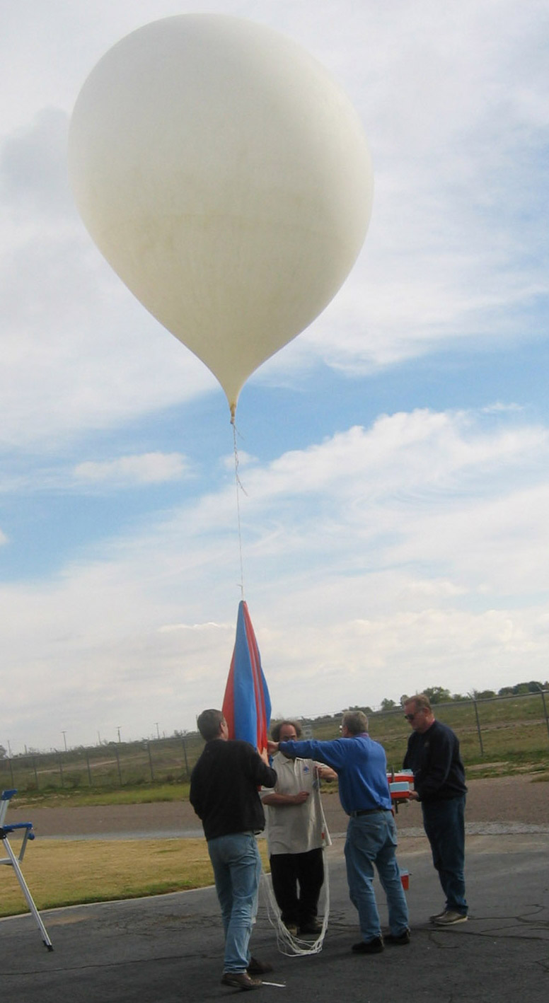 NOAA researchers prepare to release a weather balloon as part of an experiment.