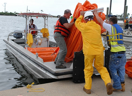 BP Contract Employees Load an Oil Containmet Boom onto a Work Boat (Navy Image)