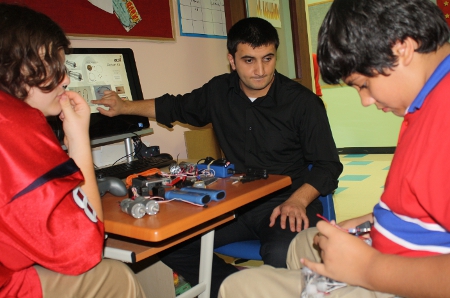 Rahman Rasulzada and students work with electrical components