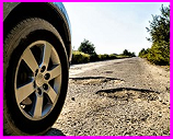 tire heading toward pothole in road
